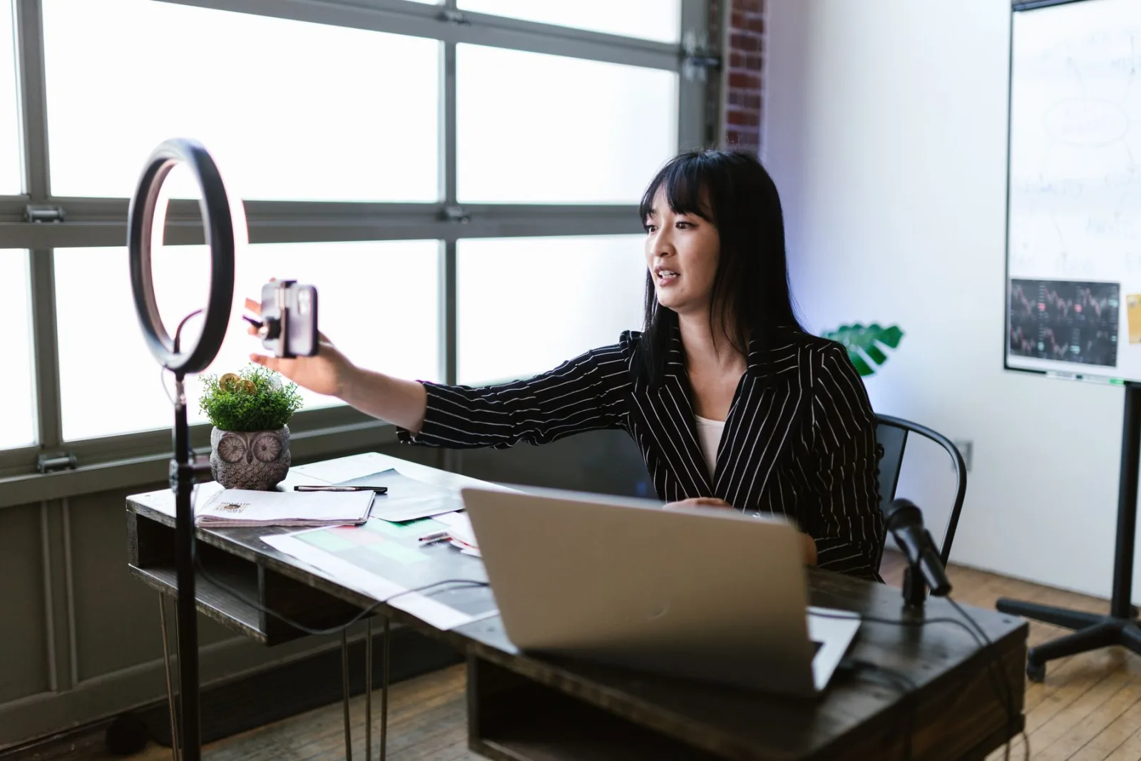 Professionnelle répondant à son audience depuis un smartphone dans son bureau